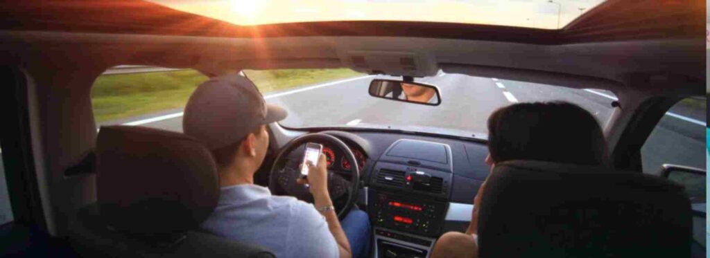 Autista che guida l'auto con lo smartphone